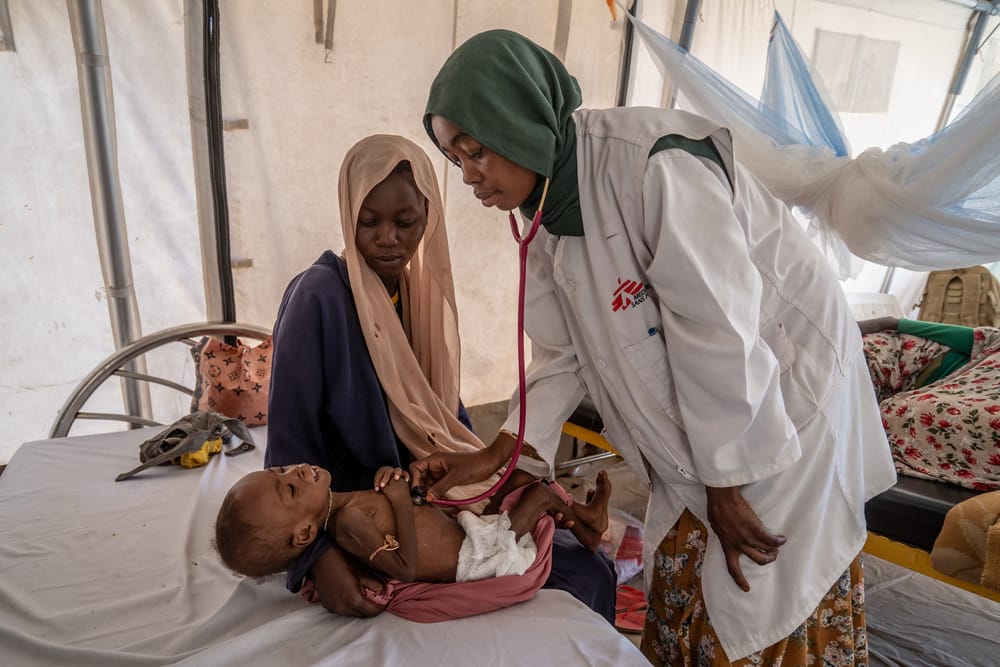 Hoitaja tutkii aliravitsemusta sairastavaa lasta sairaalassa.